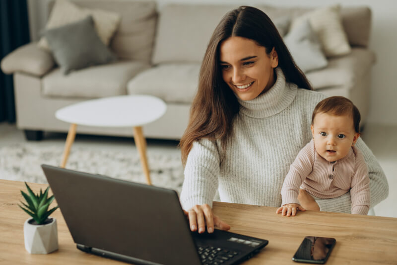 Mother with baby daughter working on computer from home - Protecting Precious Memories: A Guide to Safeguarding and Recovering Family and Wedding Photos - https://www.freepik.com/